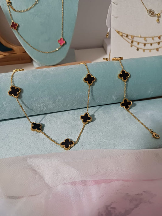 Set de collar y pulsera dorados con dijes de trébol negro – elegancia atemporal